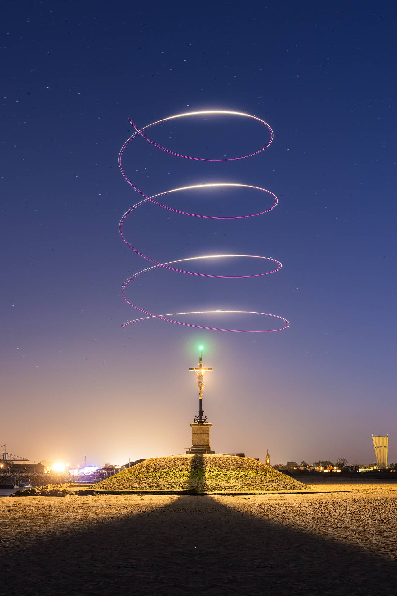 Photo d'un faisceau lumineux réalisé en lightpainting avec un drone autour de la croix du Christ à Gujan-Mestras