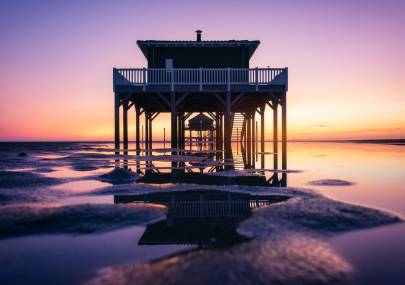Photo de Île aux oiseaux - Lever de soleil rosé sur les cabanes tchanquées